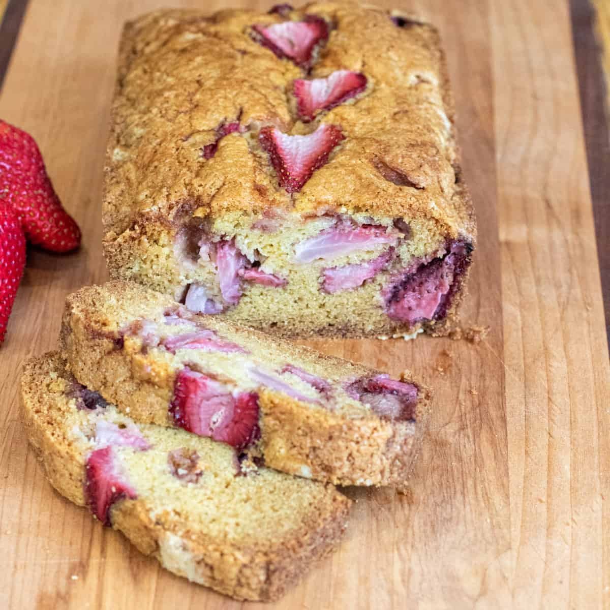 a loaf of bread with strawberries and slices.