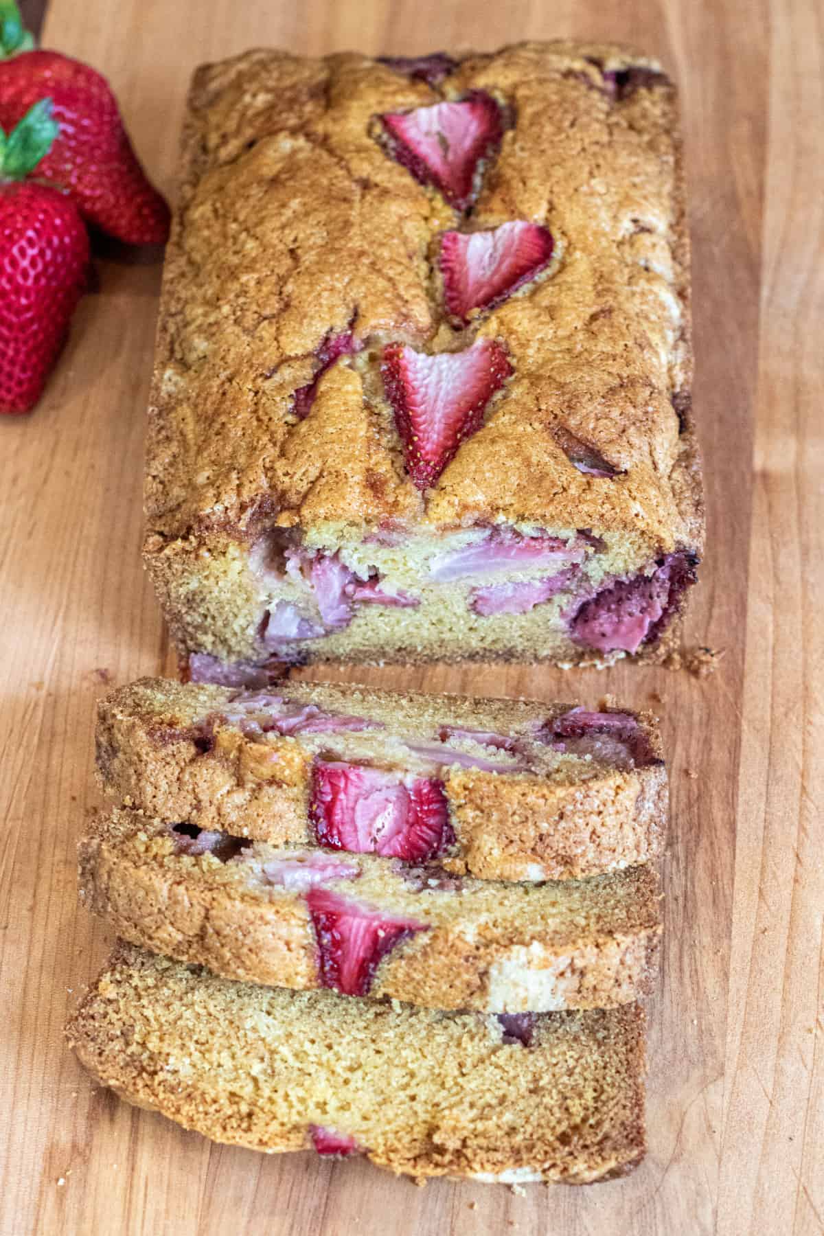 a loaf of bread with strawberries and slices.