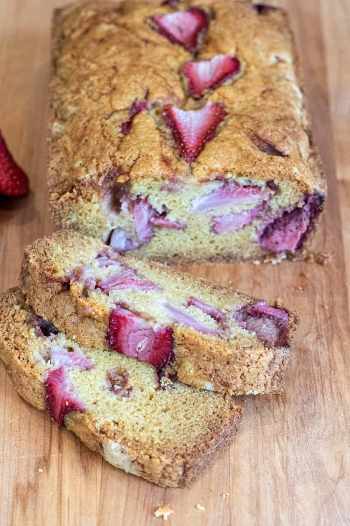 a loaf of bread with strawberries and slices.