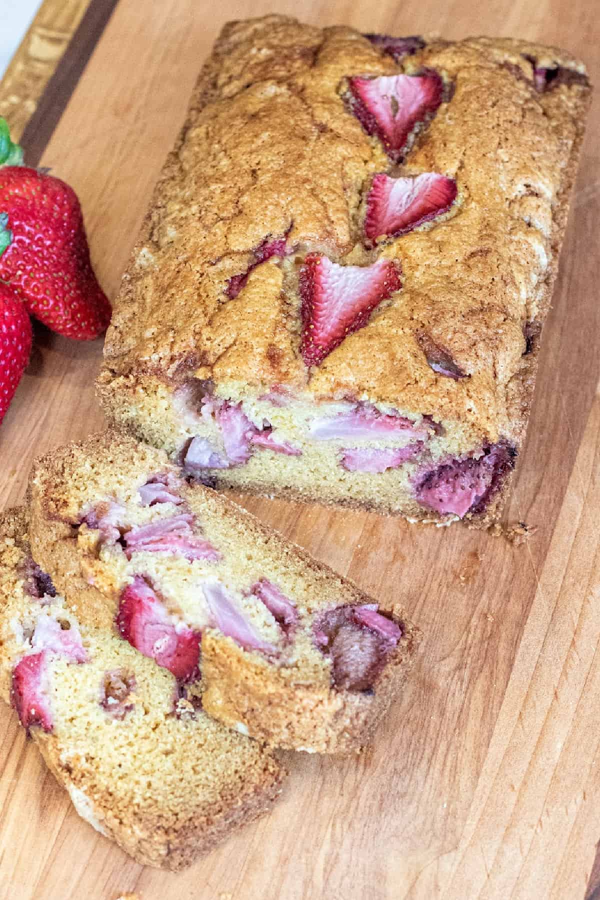 a loaf of bread with strawberries and slices.