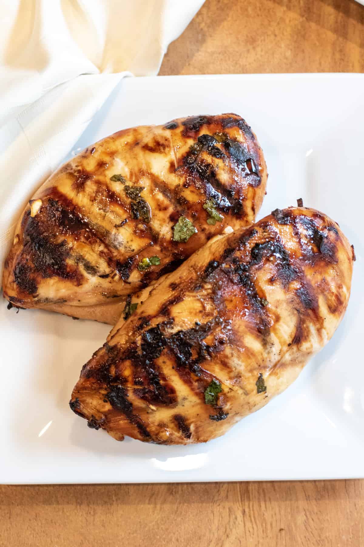 two grilled chicken breasts on a plate.