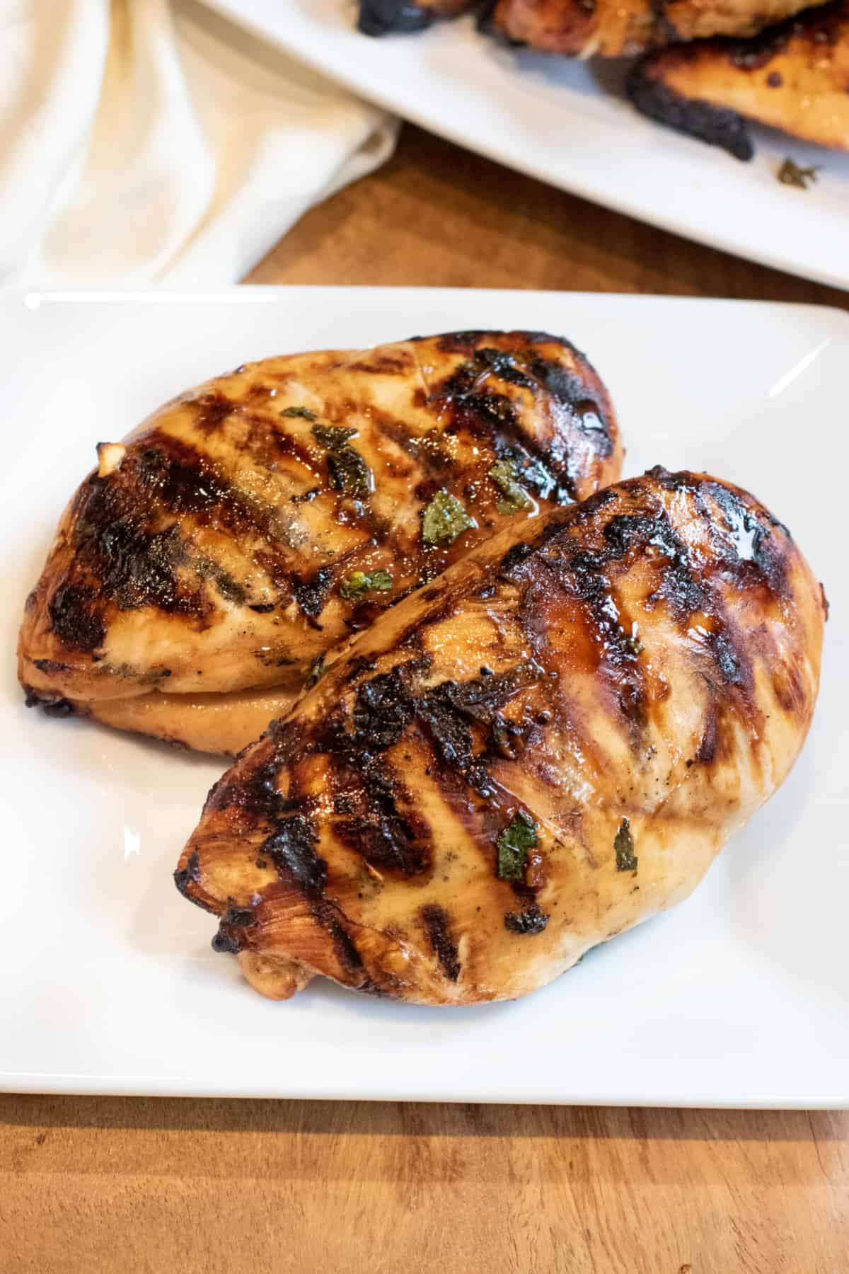 two grilled chicken breasts on a plate.