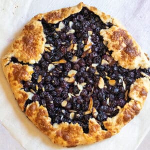 an overhead of a baked blueberry galette with almonds.