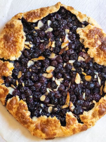 an overhead of a baked blueberry galette with almonds.