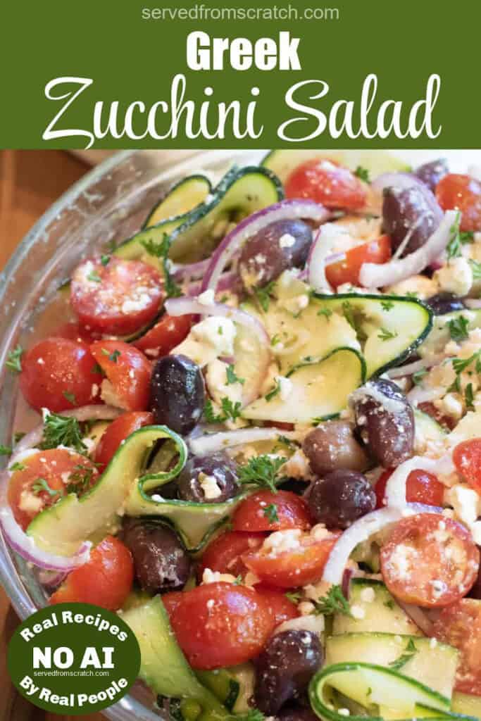 an overhead of a zucchini noodle salad with tomatoes, olives, and feta and onions with Pinterest pin text with NO AI sticker.