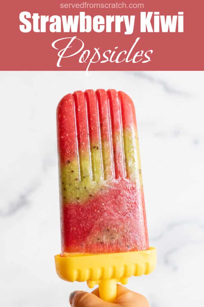 a strawberry and kiwi popsicle held by a hand with Pinterest pin text.