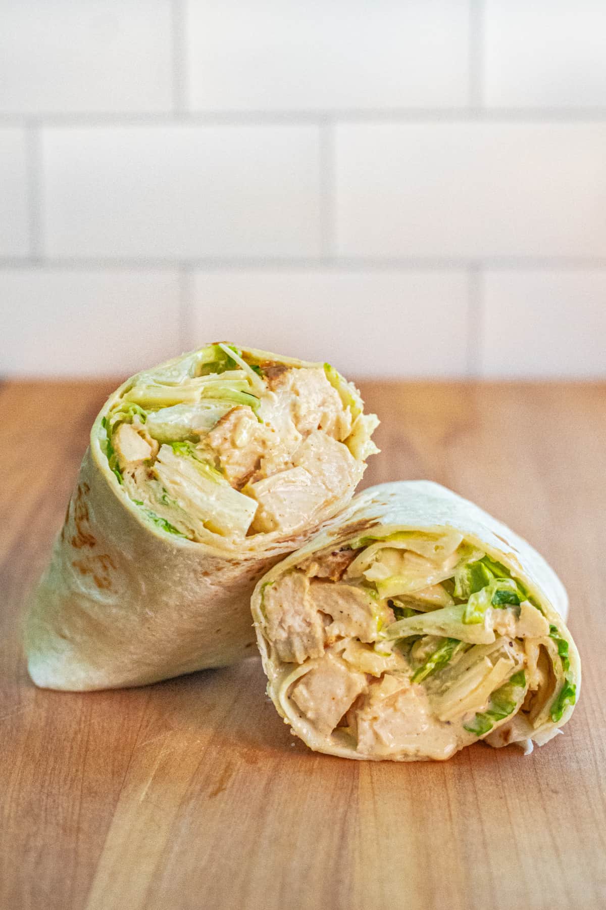 a wrap halved with chicken and lettuce.
