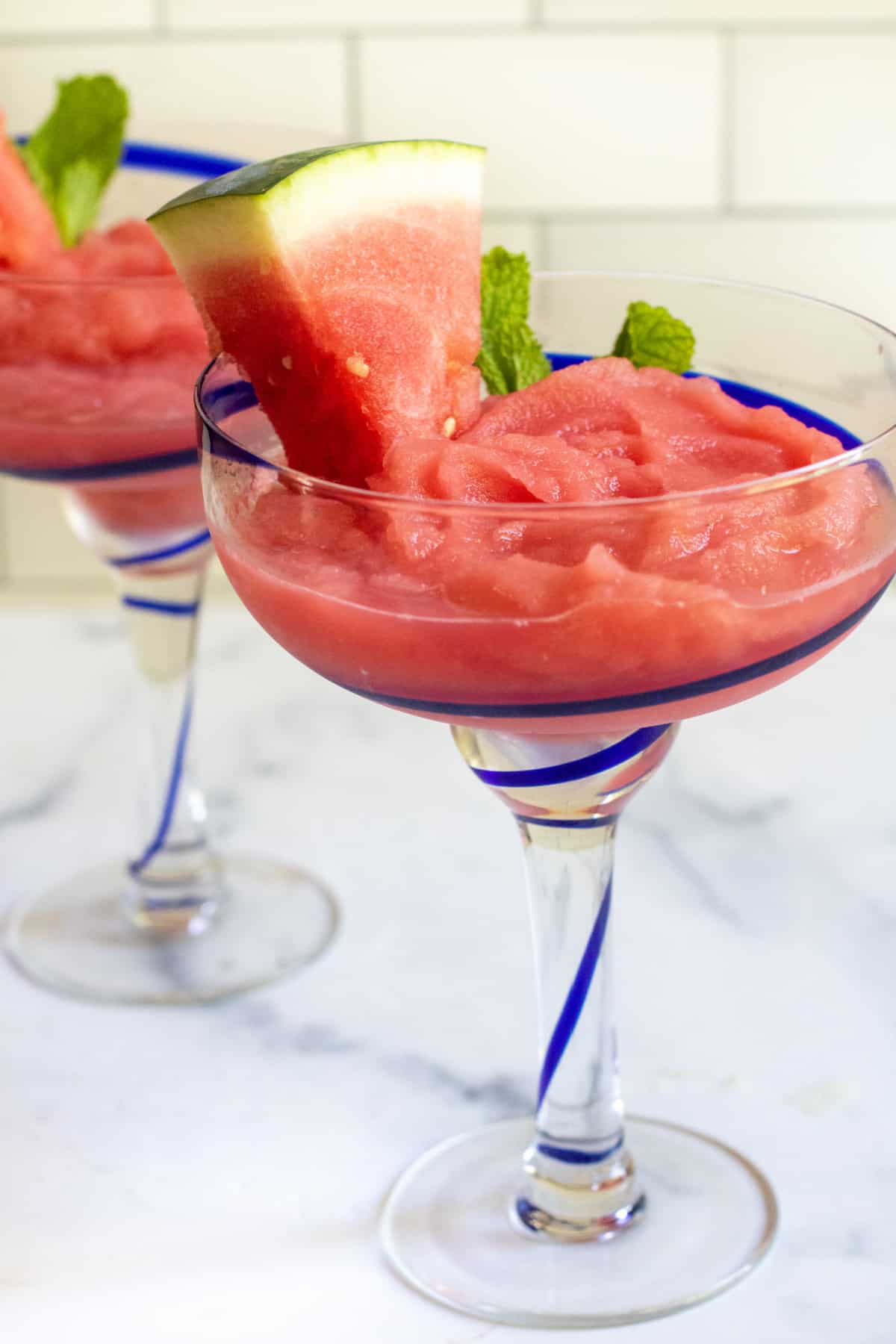 two margarita glasses with frozen watermelon daiquiris.