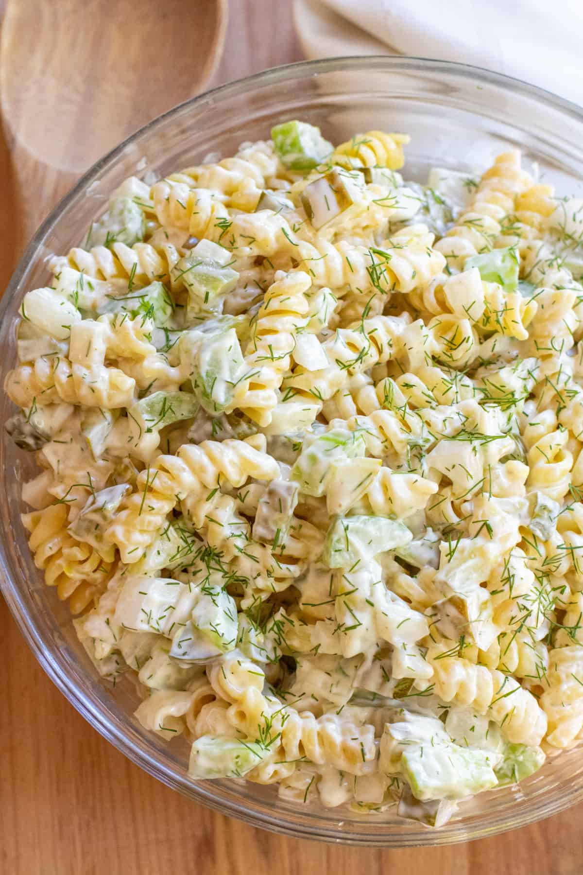 an overhead bowl of rotini pasta salad with celery and dill pickle.