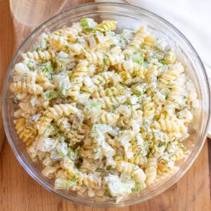 an overhead bowl of rotini pasta salad with celery and dill pickle.