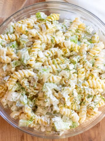 an overhead bowl of rotini pasta salad with celery and dill pickle.