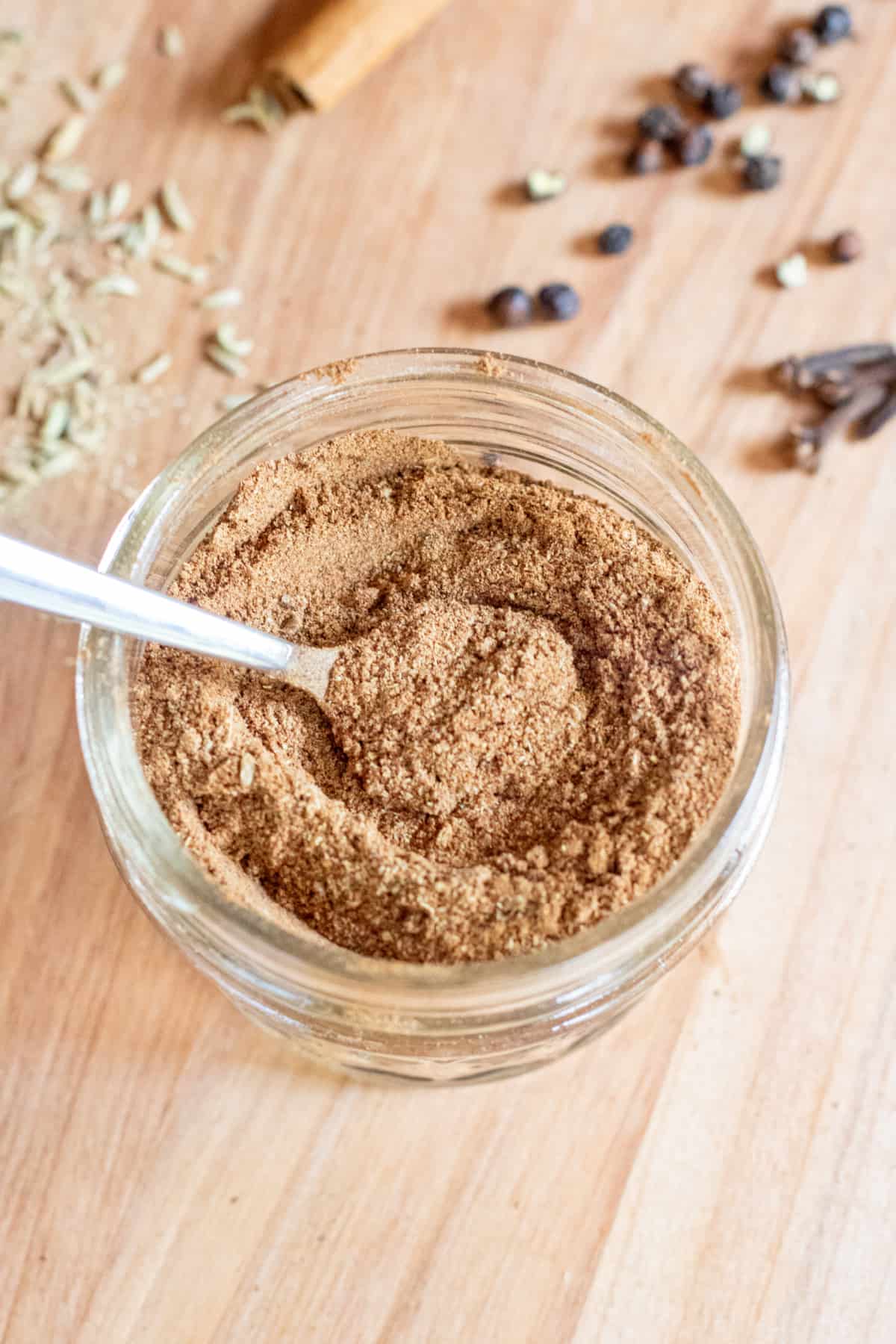 a small mason jar of diy chai spice with a little spoon.