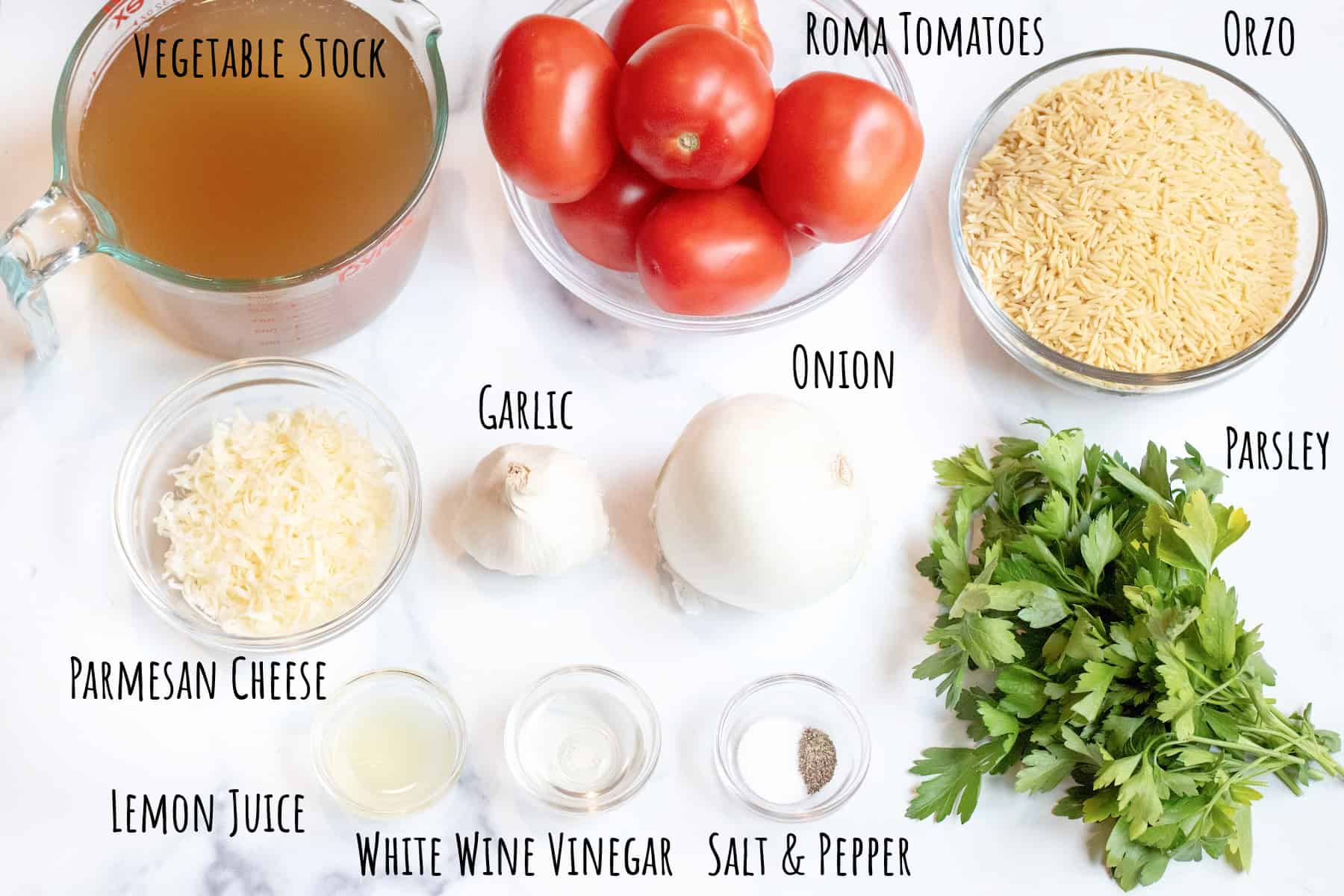 stock, a bowl of tomatoes, orzo, cheese, onion, garlic, slices, vinegar, and parsley.