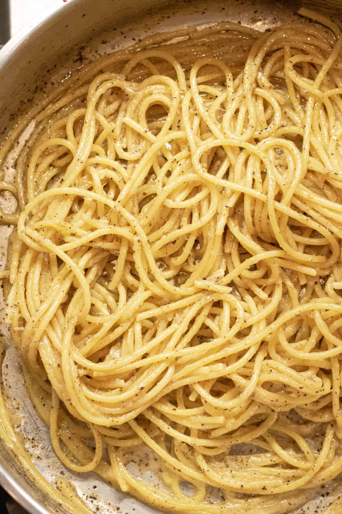 a pan with cooked spaghetti and pepper.