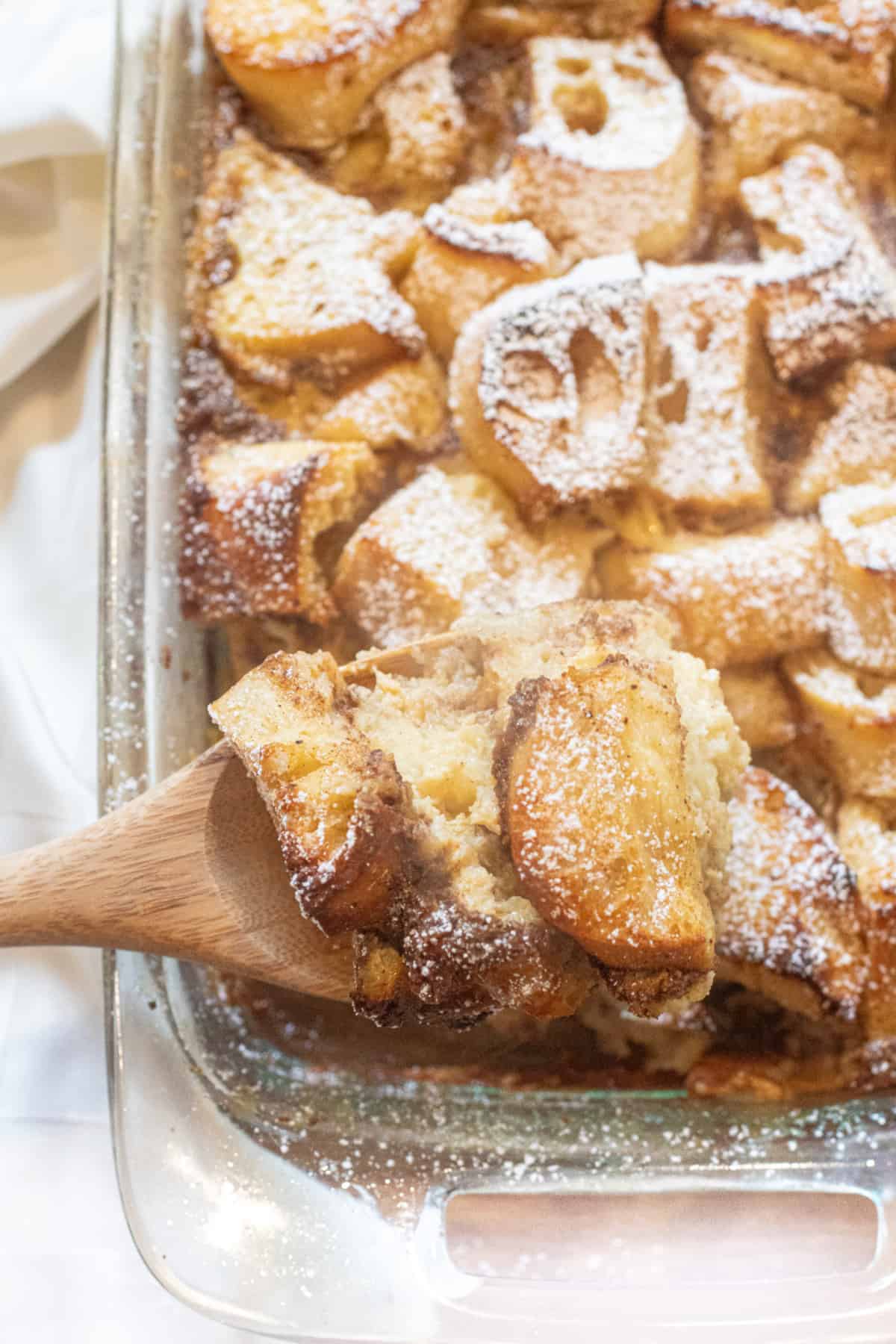 a dish of bread pudding with a wooden spoon.