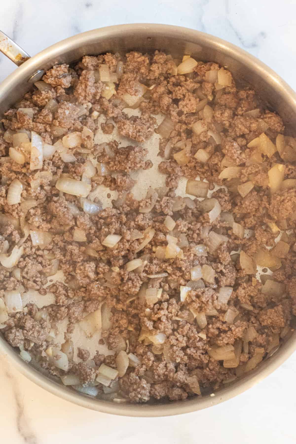 a pan of cooked ground beef with onion.