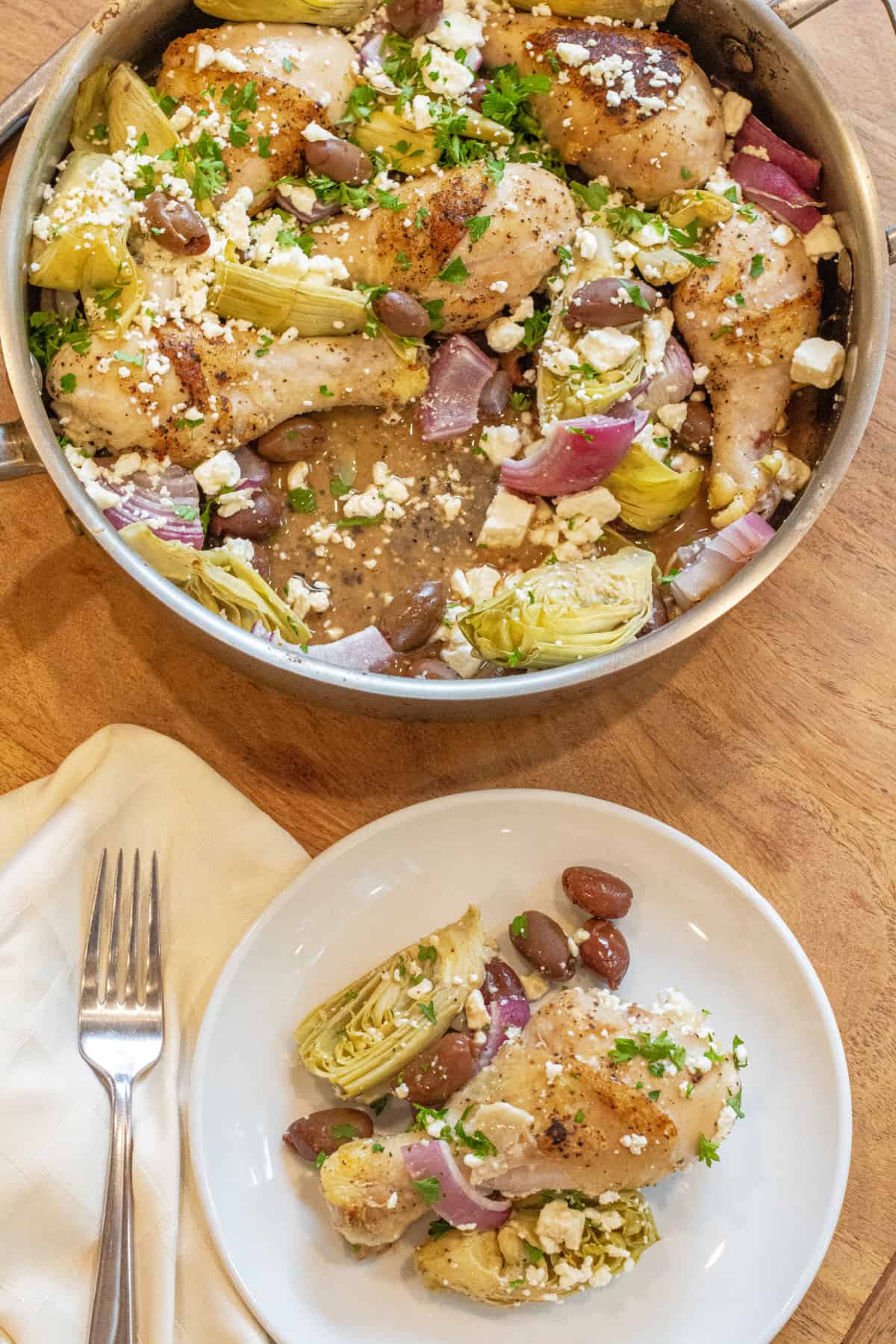 a pan with cooked chicken and olives and onions and artichokes, and plate of a chicken leg with onions and olives.