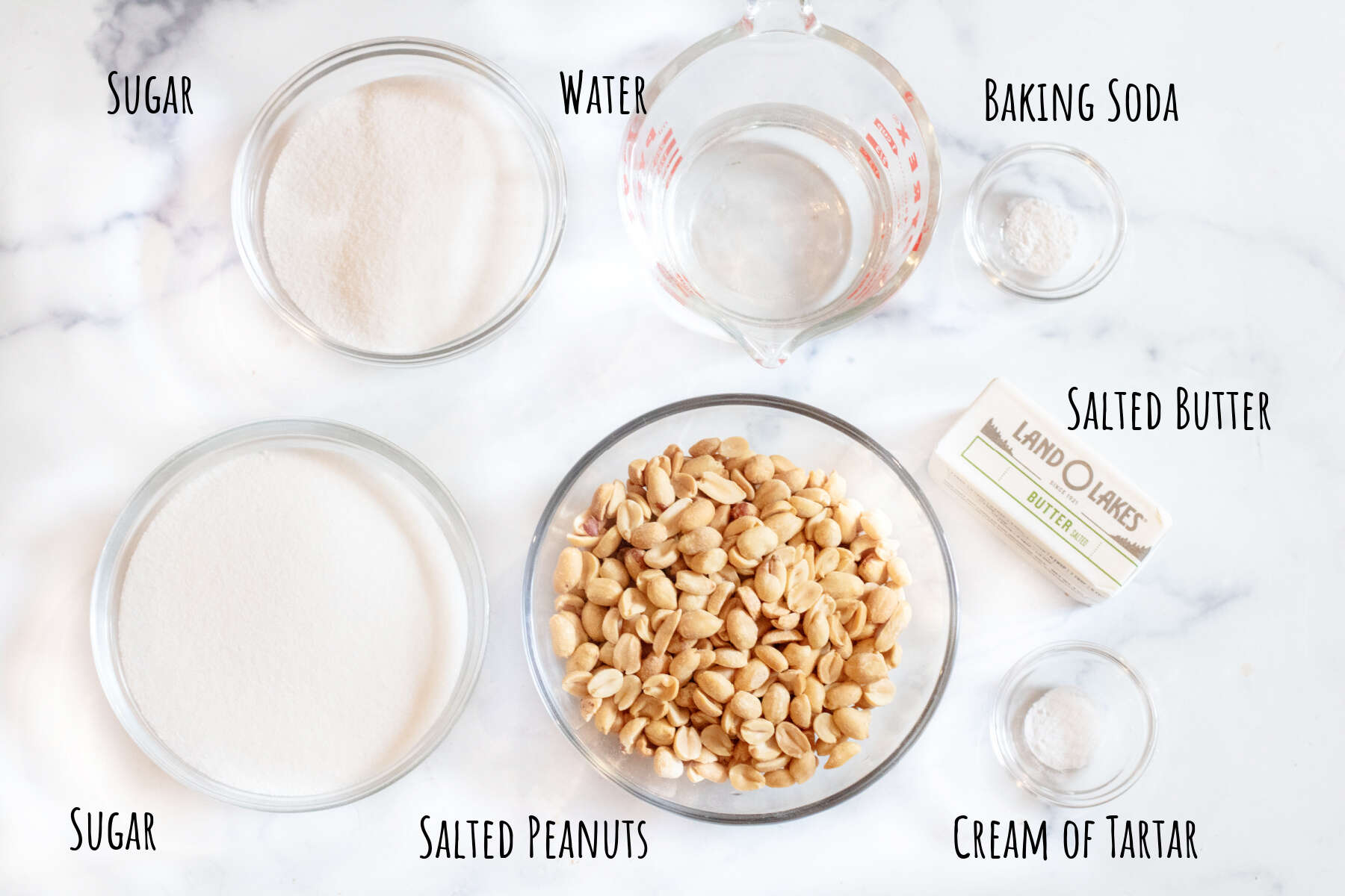 bowls of sugar, peanuts, butter, water, and little bowls of baking soda and cream of tartar.