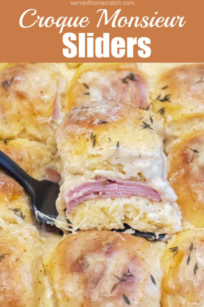 a slider with ham and bechamel sauce being held up in a pan of them with Pinterest pin text.