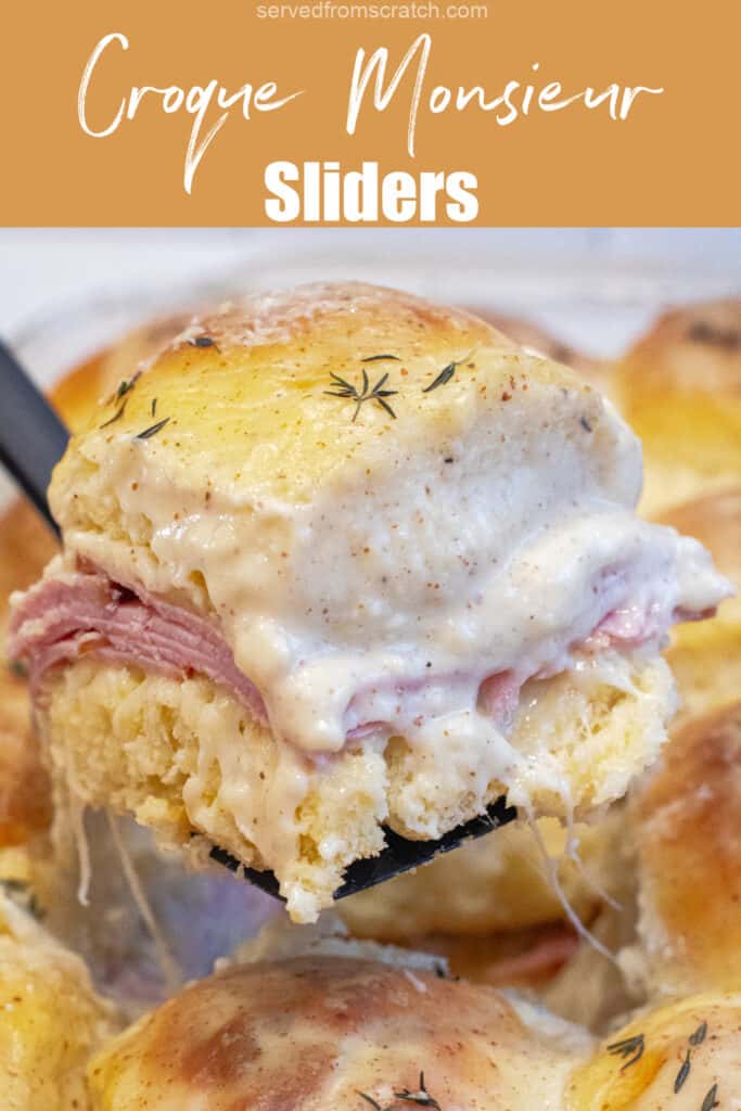 a slider with ham and bechamel sauce being held up in a pan of them with Pinterest pin text.