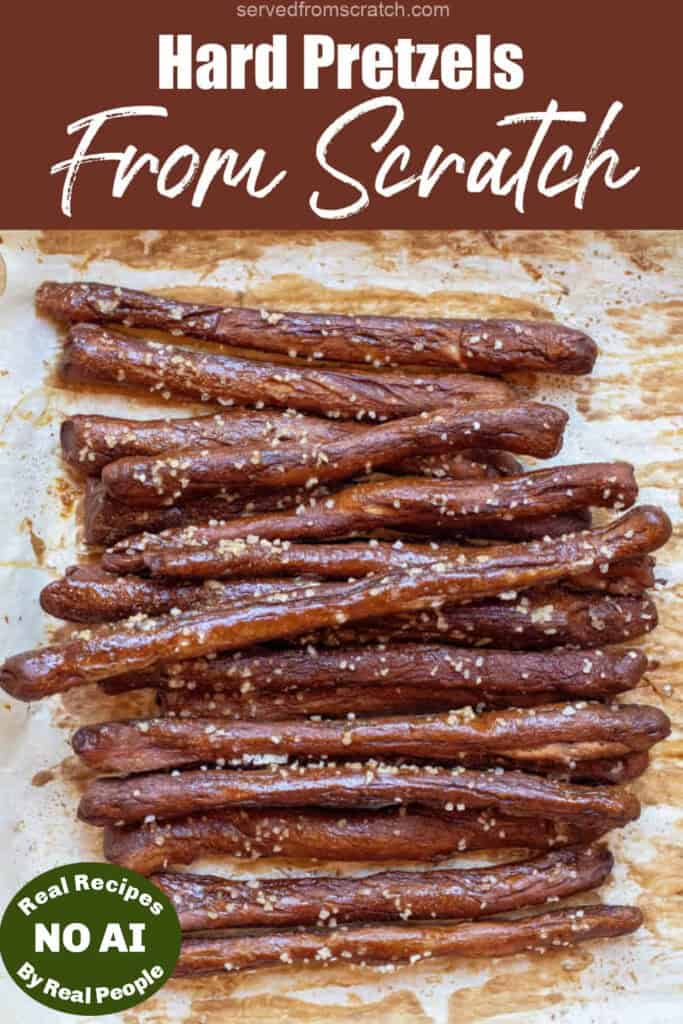 an overhead of a baking tray of hard pretzel rods with Pinterest pin text and NO AI sticker.