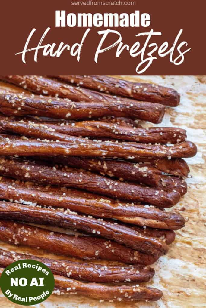 an overhead of a baking tray of hard pretzel rods with Pinterest pin text and NO AI sticker.