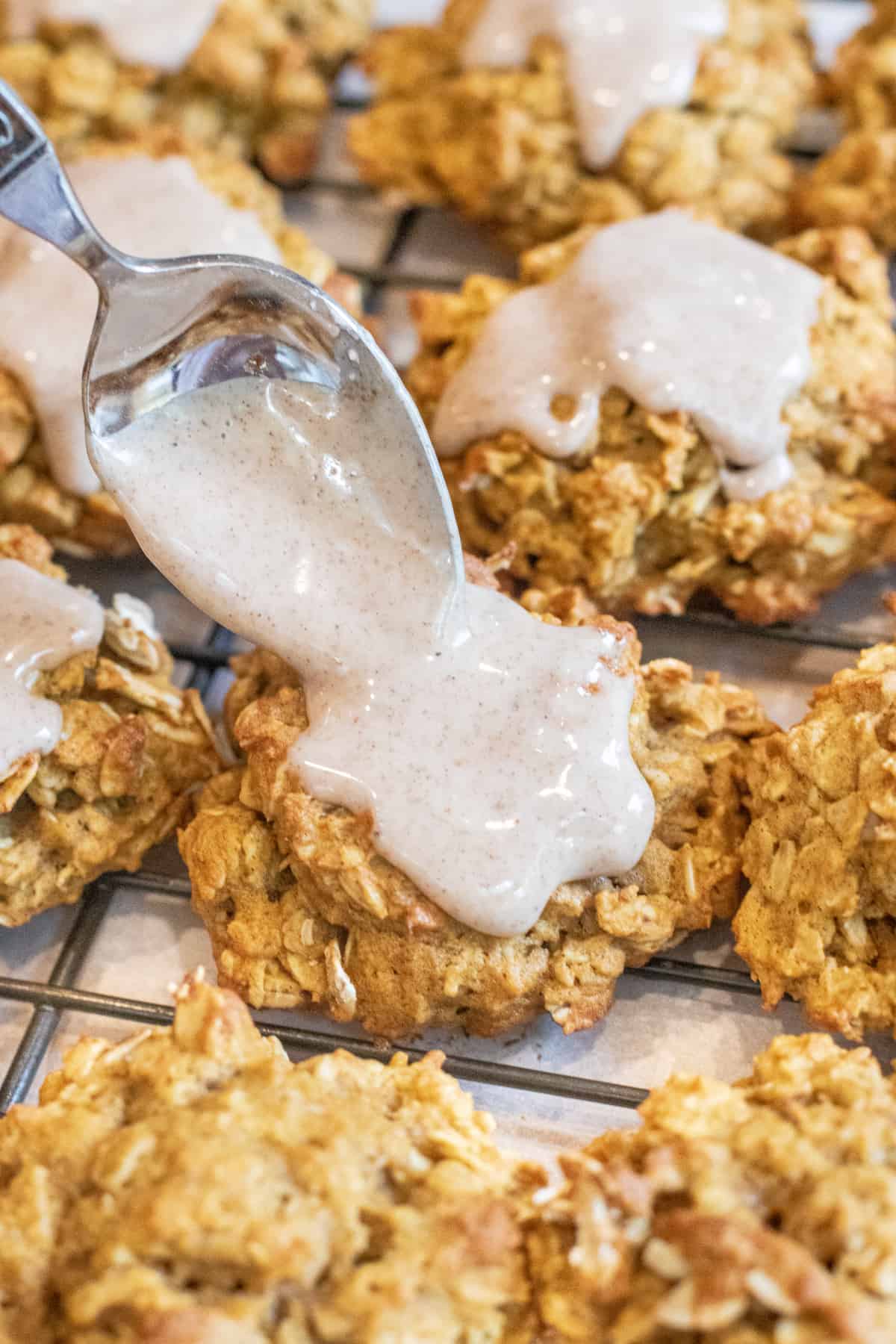 a spoon putting icing on a cookie.