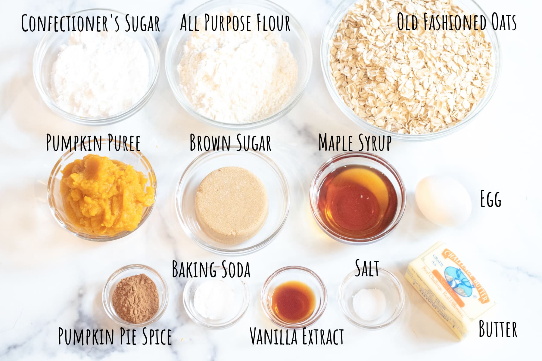 oats, pumpkin, flour, sugar, maple syrup, butter, spices, in bowls labeled.