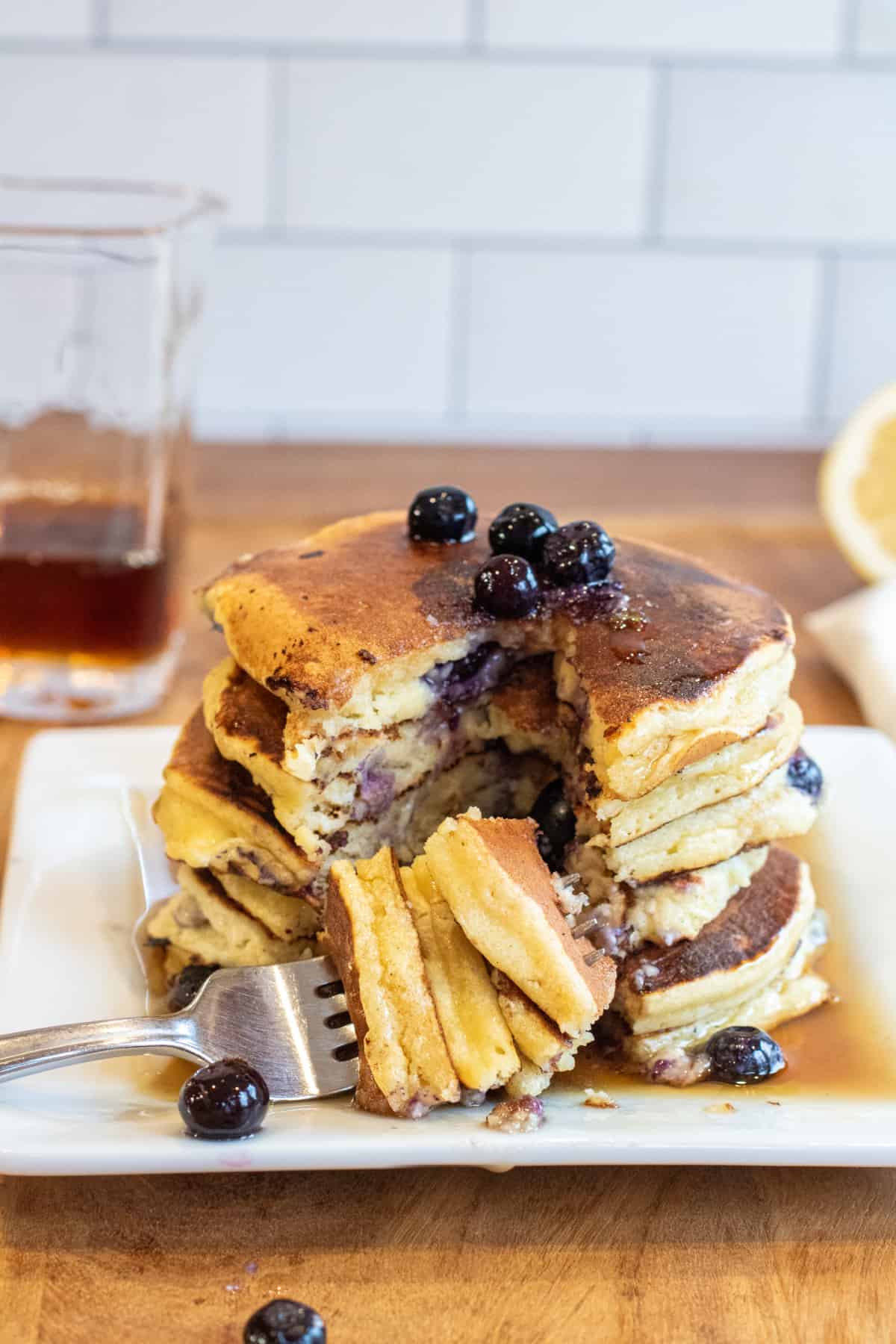 a large stack of pancakes with a fork of pancakes taken out with a fork on.