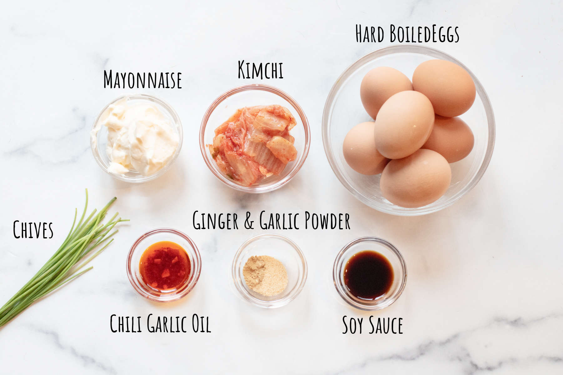 a bowl of eggs, kimchi, mayo, chives, chili garlic oil, ginger and garlic powder, and soy sauce.