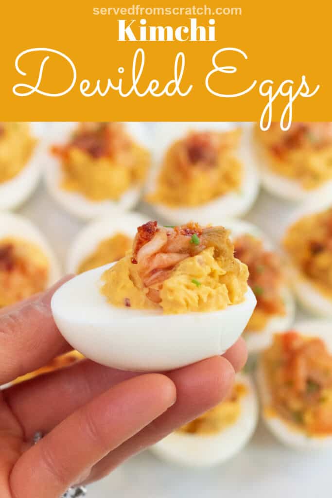 a hand holding a deviled egg topped with Kimchi with Pinterest pin text.