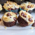 mini chocolate cupcakes with cream cheese topping and chocolate chips and walnuts on top.