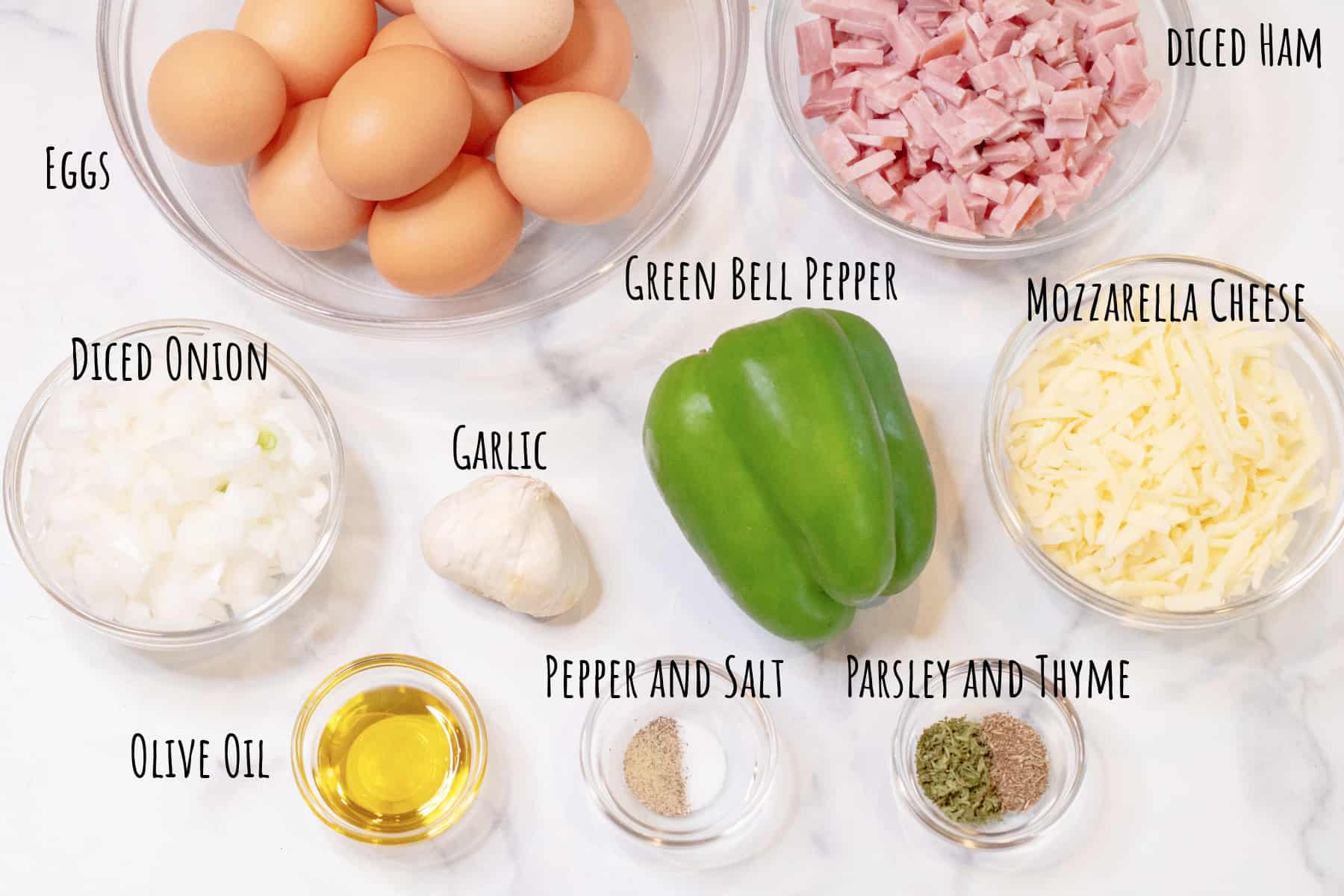 eggs, diced ham, cheese, bell pepper, garlic, spices, and chopped onion in a bowl.