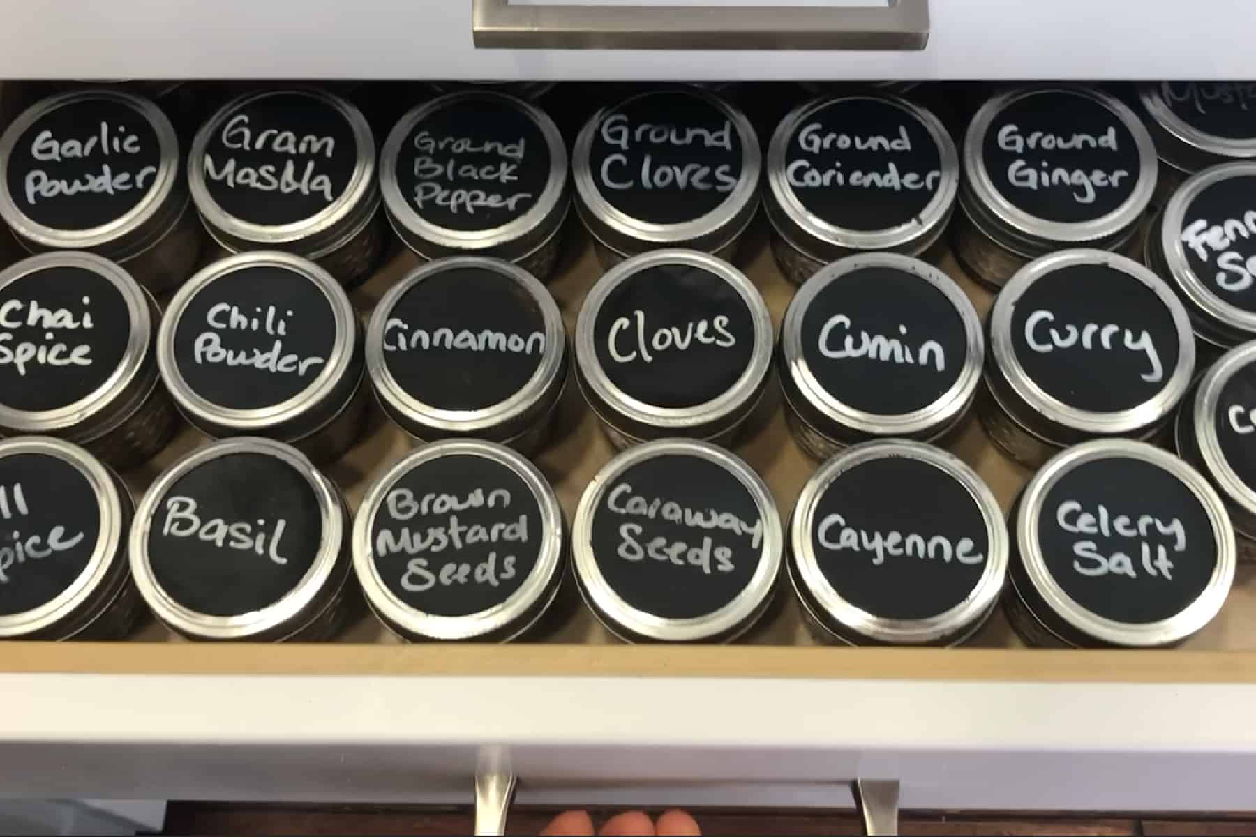 a drawer of labeled jarred spices.