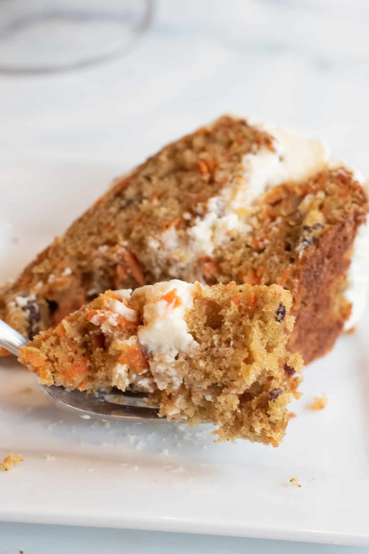 a plate with a slice of carrot cake and a forkful.