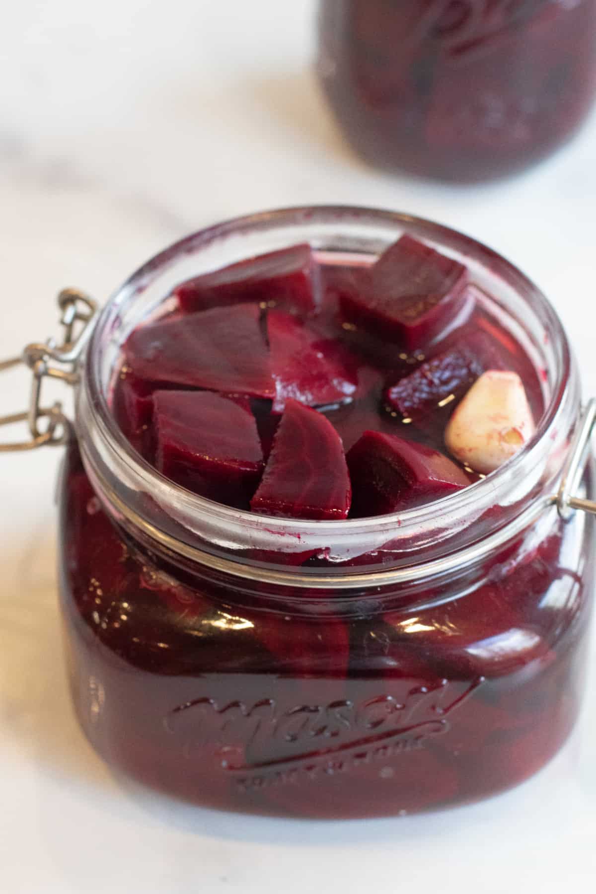 a mason jar of chopped cooked beets with liquid.