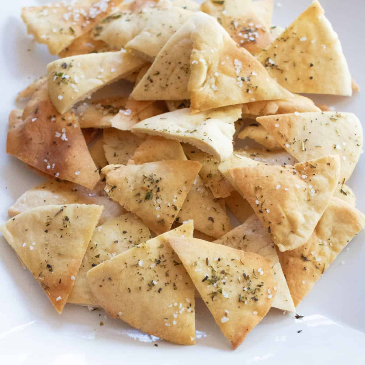 a plate of baked and seasoned and salted pita chips.
