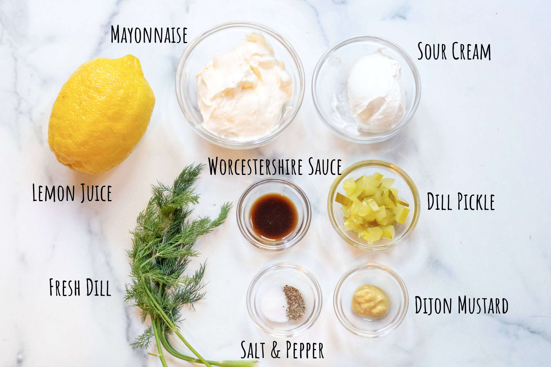bowls of mayo and sour cream, lemon, fresh dill, worschester sauce, pickles, mustard, salt and pepper, labeled. 