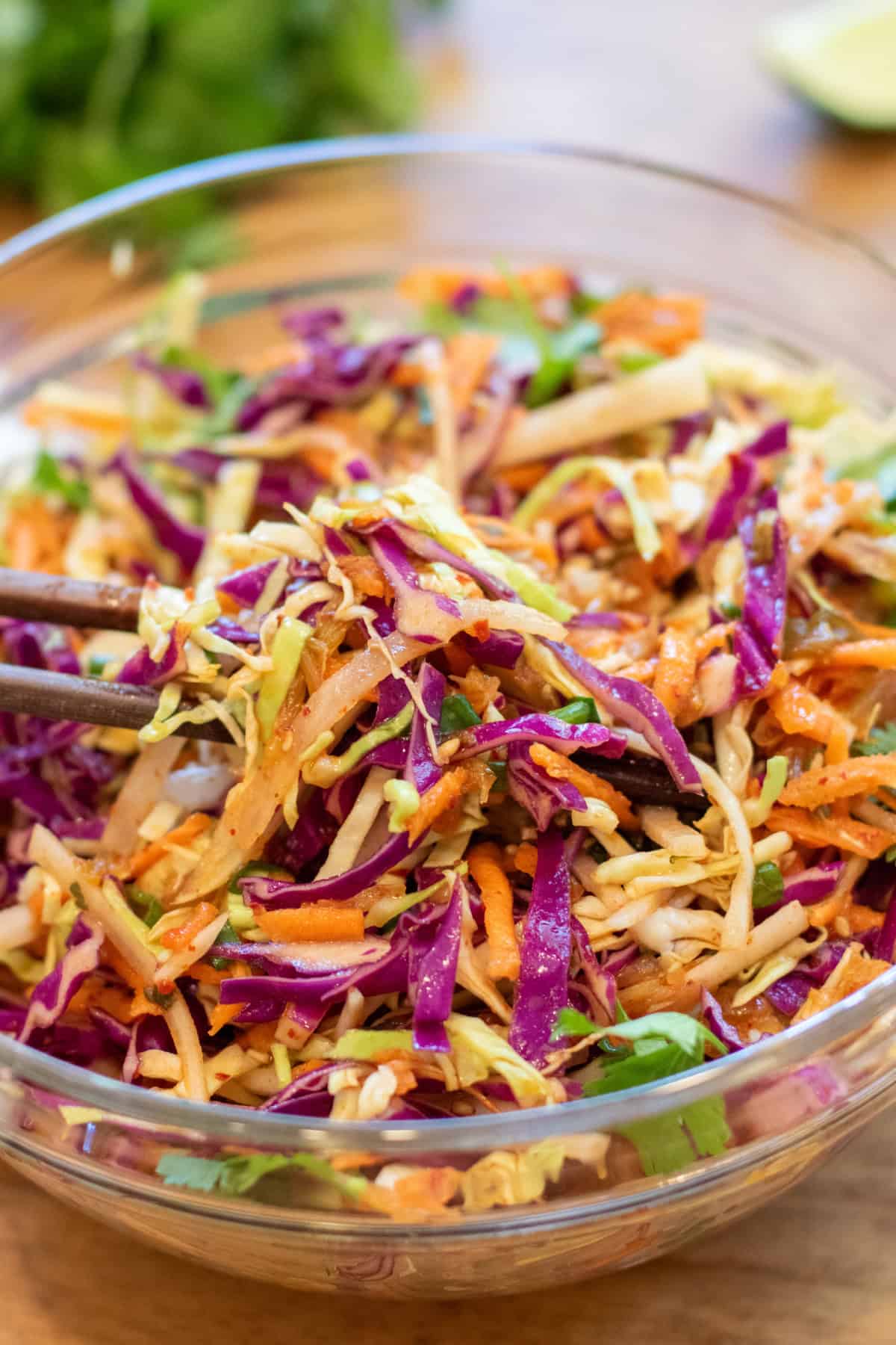 chopsticks holding up some cabbage slaw.