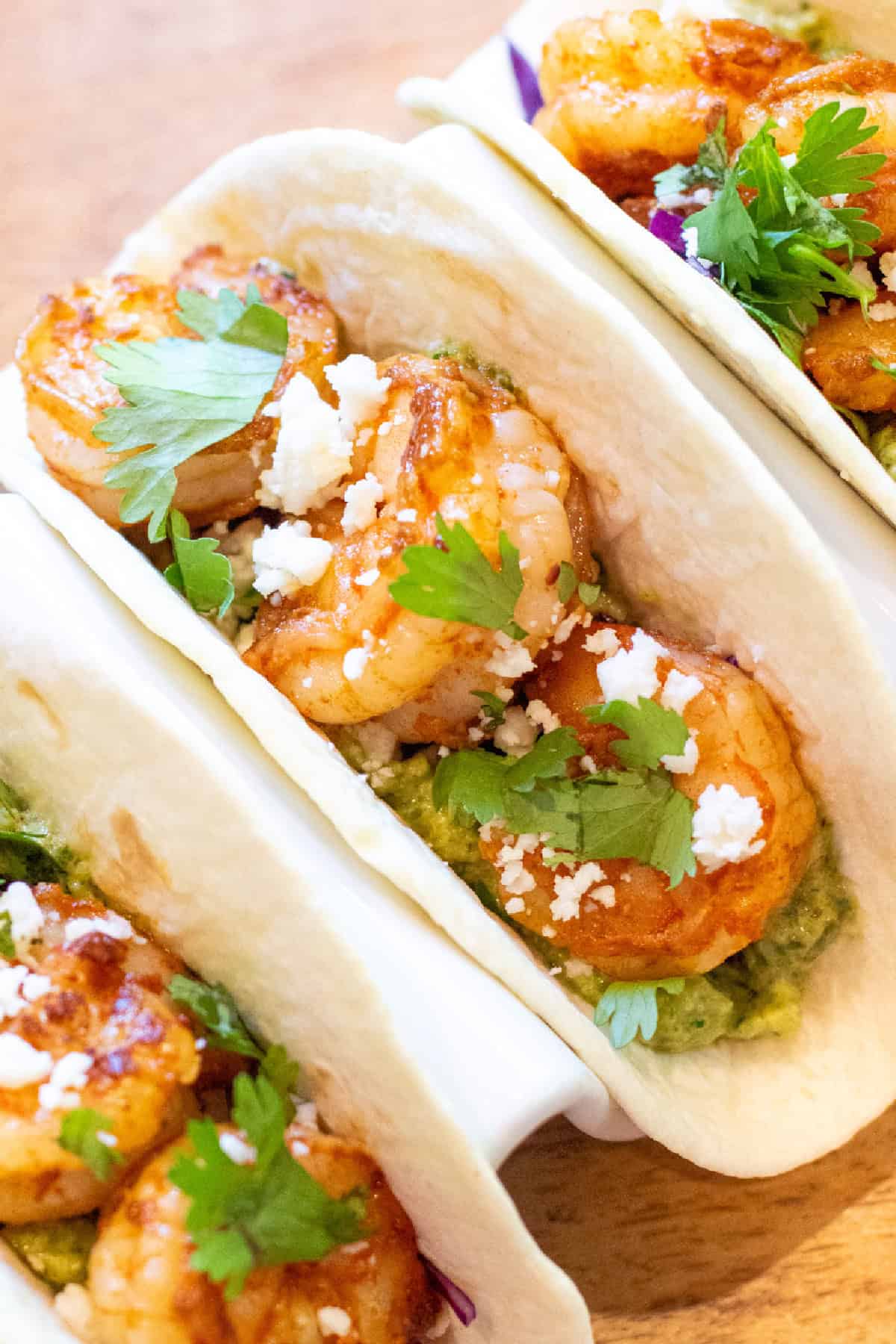 3 shrimp tacos in a holder.