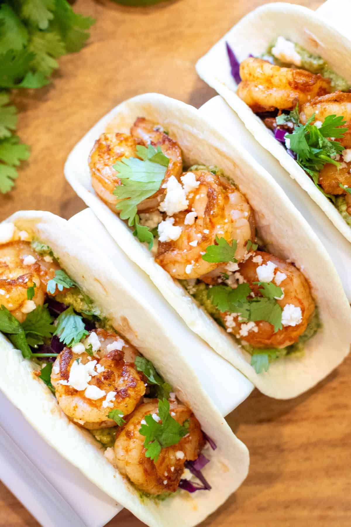 3 shrimp tacos in a holder.