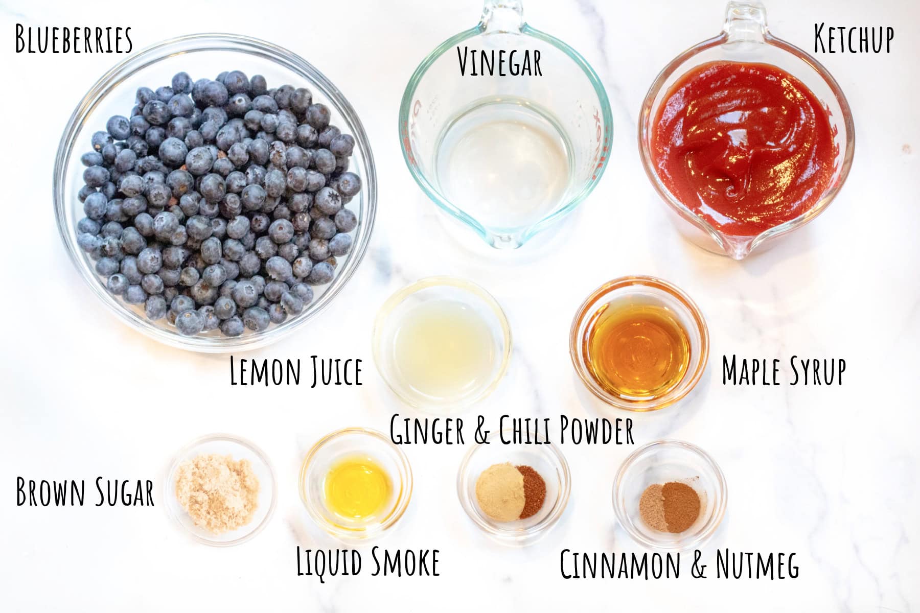 bowls of blueberries, spices, maple syrup, liquid smoke, lemon juice, vinegar, and ketchup all labeled.