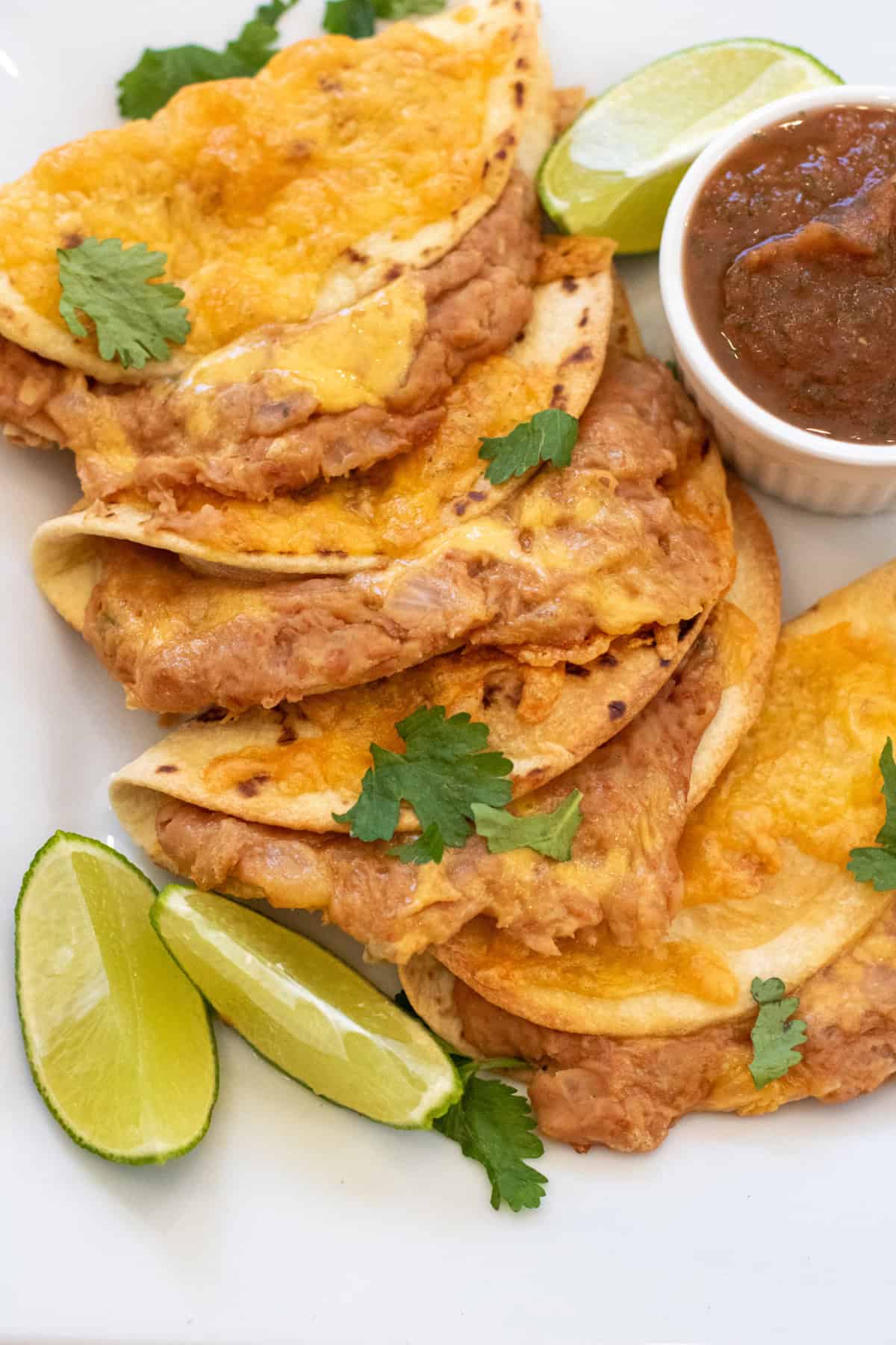 a plate of crispy tacos with crispy tacos with cheese and beans.