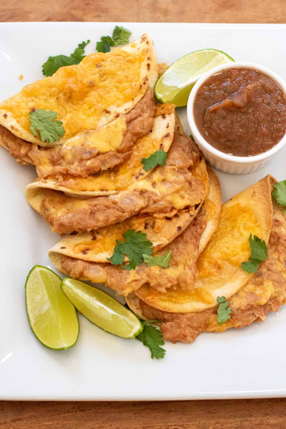 a plate of crispy tacos with crispy tacos with cheese and beans.