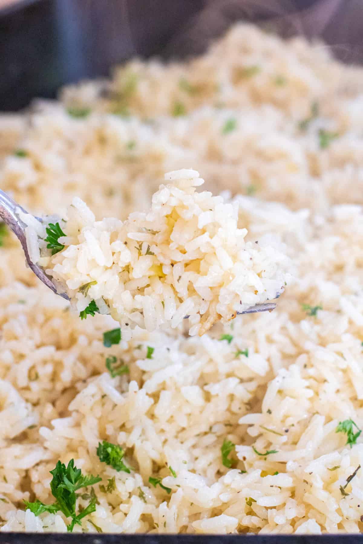 a fork holding some cooked white rice.