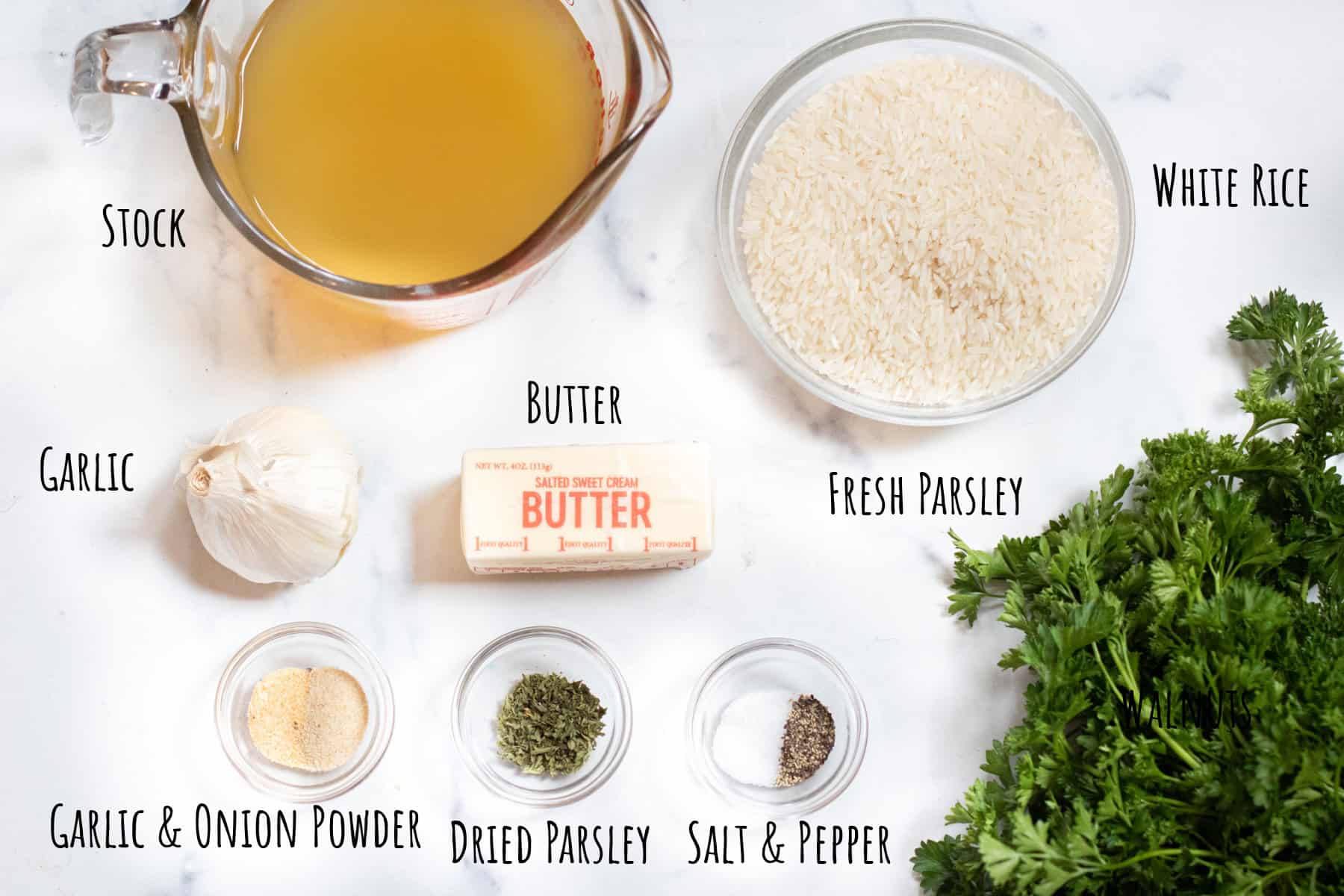 labeled bowls of stock, rice, garlic, butter, spices, salt and pepper, parsley.