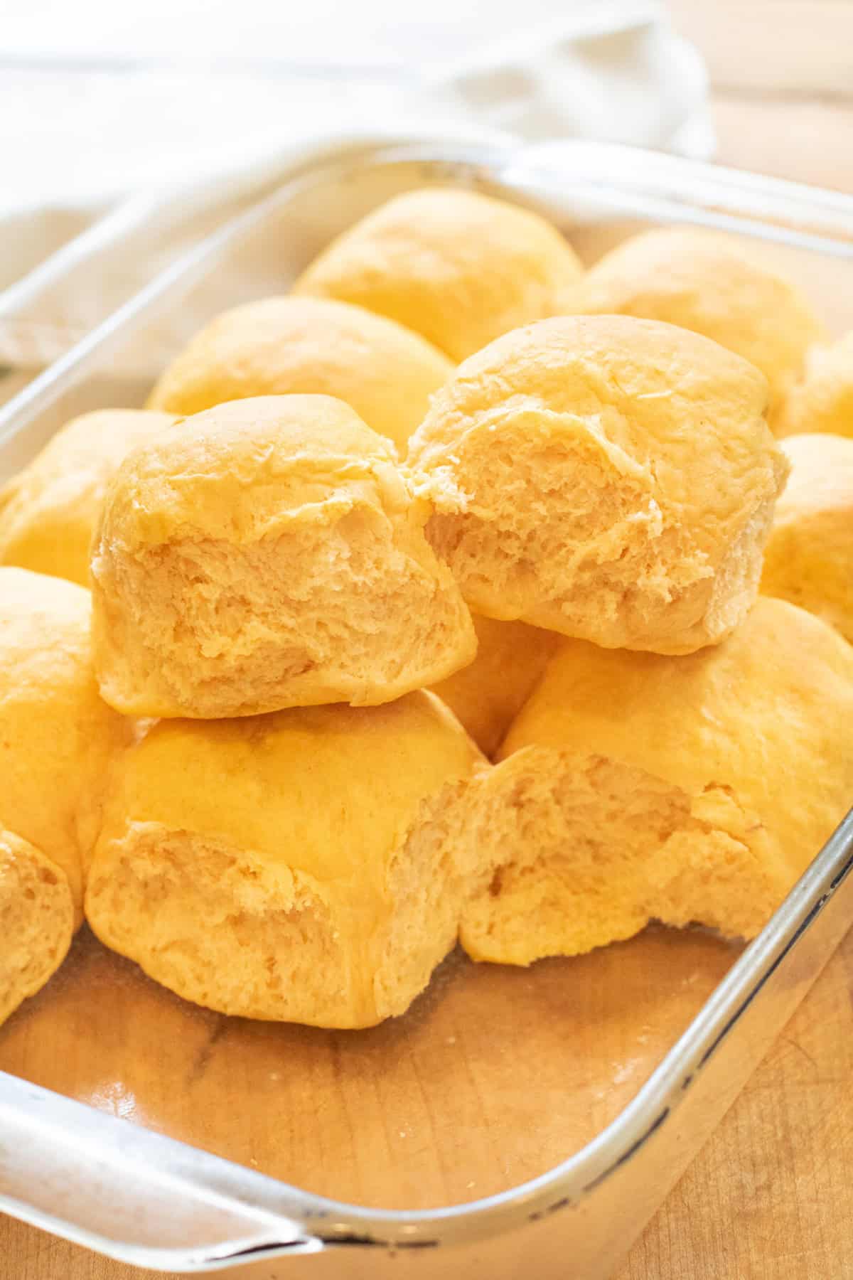 two rolls pulled out of a tray of rolls sitting on top of the other rolls.