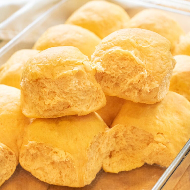 two rolls pulled out of a tray of rolls sitting on top of the other rolls.