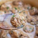 a wooden spoon with a swedish meatball on it.