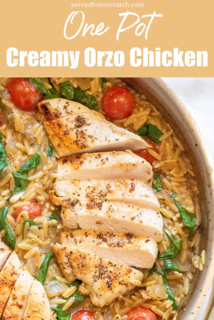 an overhead of a skillet with cooked sliced chicken and orzo and spinach and tomatoes with Pinterest pin text.